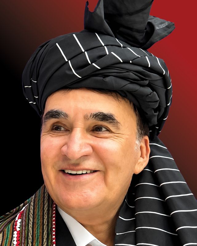 تصویر الحاج احمدشاه فقیری با لبخند، با لنگی راه‌راه سیاه و سفید و چپن گلدوزی‌شده