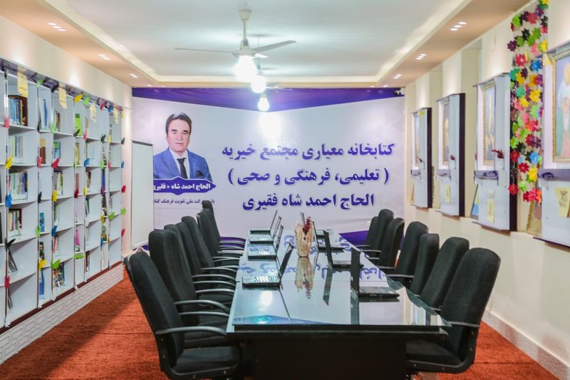 تالار مطالعه کتابخانه معیاری با قفسههای کتاب و میزی دراز